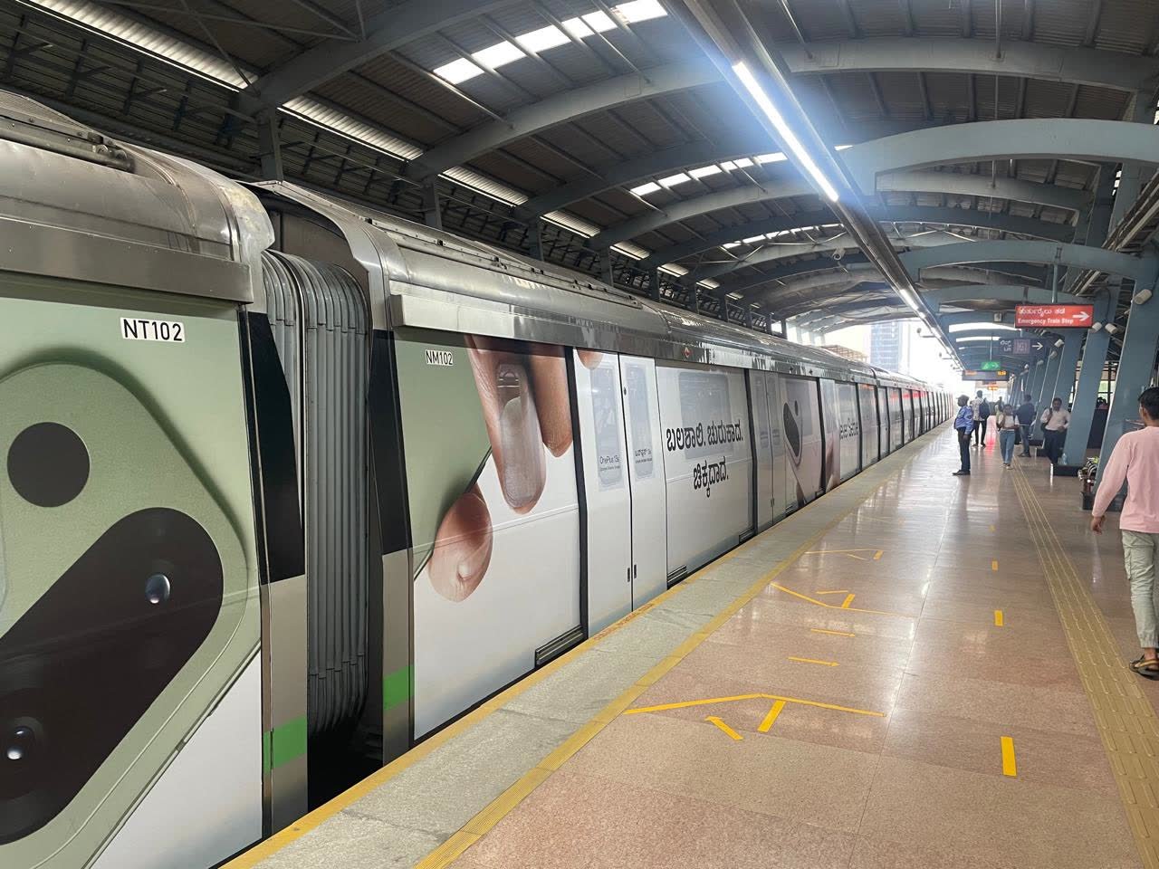 OnePlus Namma Metro train wrap at a Bengaluru platform during the day